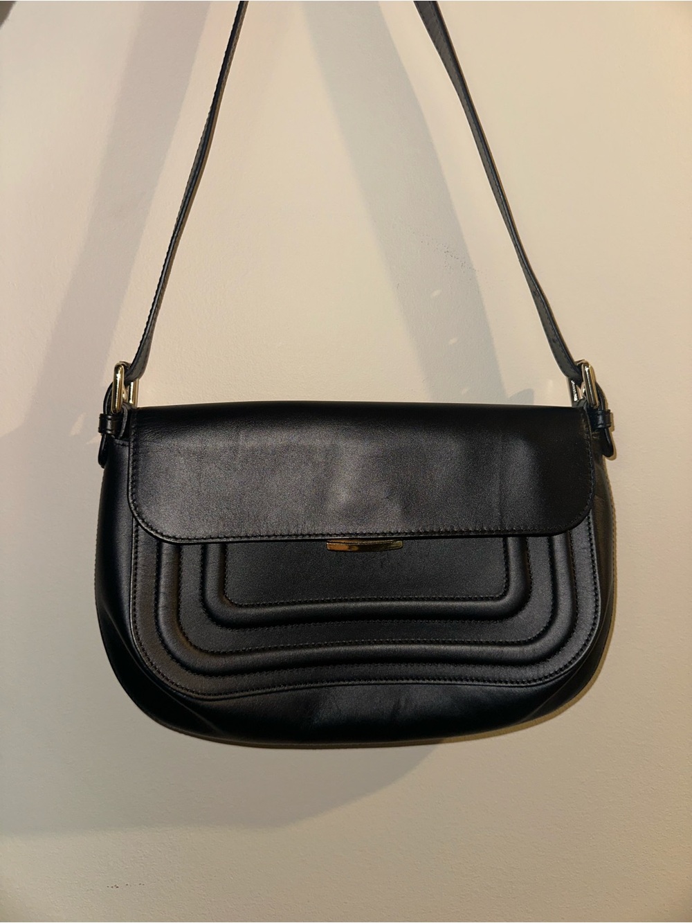 Sleek Black Leather Shoulder Bag with Curved Quilted Front